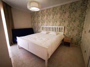 sypialnia z białym łóżkiem i tapetą w kwiaty w obiekcie Costa Sol, 1 bedroom apartment. w Aronie +9 zdjęć