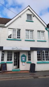 a white building with a sign in front of it at Seven Bays Stays in St Merryn