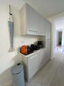 a kitchen with white cabinets and a counter top at Calme et ensoleillée Maison au pied de la plage entre St Palais sur Mer et Royan in Vaux-sur-Mer