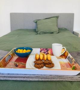 un vassoio di prodotti alimentari con biscotti e frutta su un letto di Appartement centre ville avec terrasse + petit dej a Nancy
