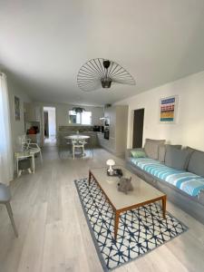 a living room with a couch and a table at Calme et ensoleillée Maison au pied de la plage entre St Palais sur Mer et Royan in Vaux-sur-Mer