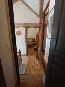 una puerta abierta a una habitación con un sofá en ecurie le buguet en Saint-Antoine-Cumond