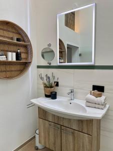 ein Bad mit einem Waschbecken und einem Spiegel in der Unterkunft Ferienwohnung d.d. Chalet in Aitrach