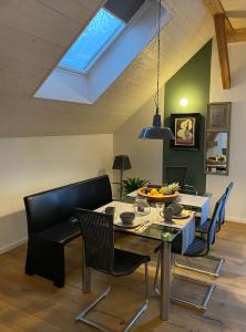 ein Esszimmer mit einem Dachfenster sowie einem Tisch und Stühlen in der Unterkunft Ferienwohnung d.d. Chalet in Aitrach