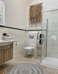 a bathroom with a toilet and a glass shower at Ferienwohnung d.d. Chalet in Aitrach