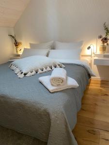 1 dormitorio con 1 cama con toallas en Ferienwohnung d.d. Chalet, en Aitrach