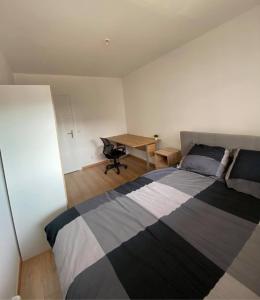 una camera con letto e scrivania di Appartement centre ville avec terrasse + petit dej a Nancy