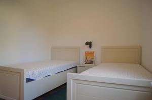 dos camas sentadas una al lado de la otra en un dormitorio en Reetdachhaus Hasel 2, en Poseritz