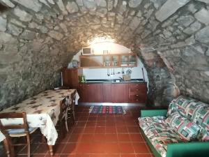 a room with a table and a kitchen in a stone wall at Casa Sasso in Tavernola Bergamasca