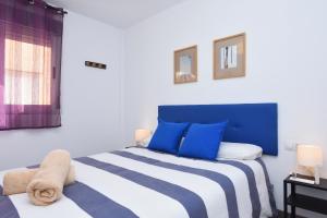 a bedroom with a blue and white bed and a window at Cabo de Gata in Carboneras