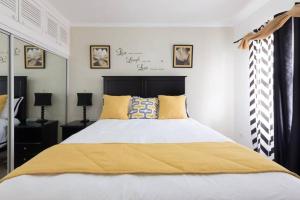 1 dormitorio con 1 cama grande con manta amarilla en The Brompton's@Home, en Kingston
