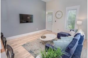 Una sala de estar con un sofá azul y una mesa. en Incredible New 3BR2BA Near Downtown, en San Antonio