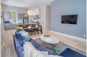 sala de estar y cocina con sofá azul y mesa en Incredible New 3BR2BA Near Downtown, en San Antonio