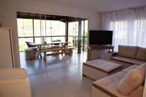 a living room with a couch and a tv at Chalé com lazer no Hotel Fazenda China Park ES in Domingos Martins