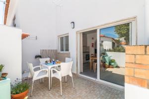 a patio with a table and chairs and a sliding glass door at Casa Mar Praia dos Pescadores By ALzira in Albufeira