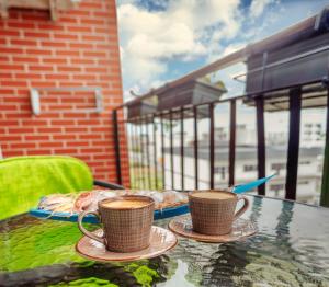 two cups of coffee on a table on a balcony at Duo Apartament in Năvodari