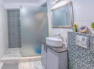 een badkamer met een wastafel en een spiegel bij Duo Apartament in Năvodari