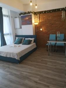 een slaapkamer met een bed en een bakstenen muur bij Duo Apartament in Năvodari