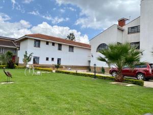 uma casa com um jardim verde com uma casa em Lovely 2 and 1 bedroom guest units Karen em Nairobi