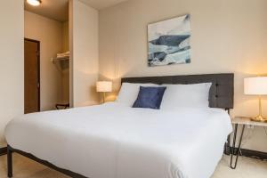a bedroom with a large white bed and two lamps at Kasa Westown Milwaukee in Milwaukee