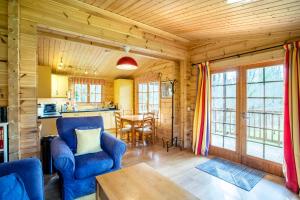 uma sala de estar com cadeiras azuis e uma mesa em Willowbank Lodges em Oare