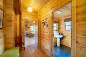 uma casa de banho com paredes de madeira e um lavatório num quarto em Willowbank Lodges em Oare