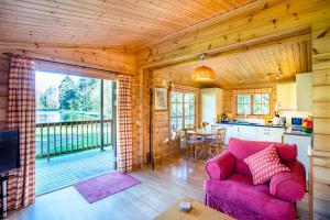 a living room with a purple couch and a kitchen at Willowbank Lodges in Oare