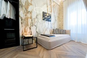 a living room with a white bed and a table at Nero Luxury Suites in Cagliari