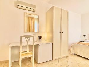 a room with a desk and a bed and a mirror at Hotel Sylesia in Letojanni