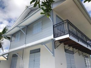 Cette maison blanche dispose d'un balcon. dans l'établissement VILLA CORNELIE, à Cayenne
