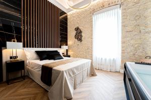 a bedroom with a large bed and a large window at Nero Luxury Suites in Cagliari