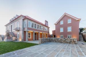 a large pink house with a stone driveway at Casa Noronha Lima - Historic Stay in Alvarenga +46 photos