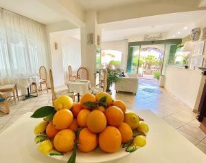a bowl of oranges on a table in a living room at Hotel Sylesia in Letojanni