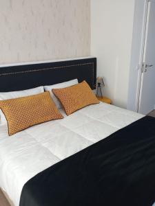 a bed with two orange pillows on top of it at Alojamento Local Vitoria in Batalha
