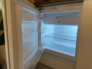 an empty refrigerator with its door open in a kitchen at Bed en Koffie Casa Mañana de Koog in De Koog