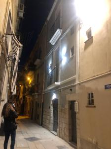 バーリにあるDimora del Borgo Anticoの夜の路地を歩く女