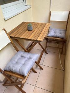 Una mesa de madera y dos sillas con almohadas encima. en Centar NS, en Novi Sad 13 fotos más