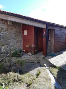 a stone house with a wooden door and a porch at Caramulo - Abrigo Serrano in Carvalhal da Mulher
