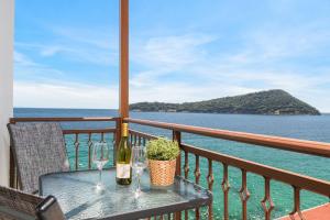 einen Tisch mit zwei Weinflaschen und Gläsern auf dem Balkon in der Unterkunft Faros View in Kinira