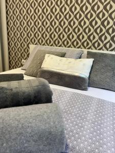 1 dormitorio con 2 camas con almohadas y pared en Centar NS, en Novi Sad