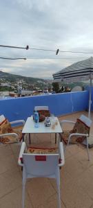 een witte tafel en stoelen op een balkon met uitzicht bij Casa Lotfi 1 in Chefchaouene