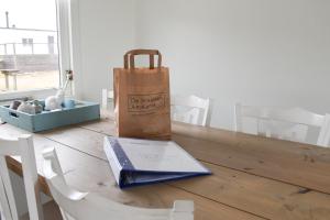 a table with a paper bag and a book on it at Kobbe in Ballum