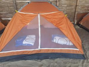 an orange and blue tent sitting on the sand at Pepon Surf Camp in Máncora