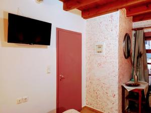 ハニア・タウンにあるCaza Latinaの赤いドアと壁にテレビが備わる部屋