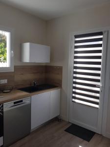 a kitchen with a sink and a window with blinds at EOLE - Maison Saint Jean de Monts - 2 pièces - 4 personnes in Saint-Jean-de-Monts