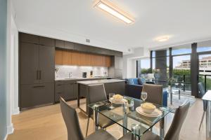 a kitchen and dining room with a glass table and chairs at Global Luxury Suites at Tribeca in Washington