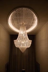 a large chandelier hanging from a ceiling in a room at Hotel Villa Pascucci in Durrës