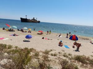 a group of people on a beach with umbrellas at Nasty Apartament in Costinesti