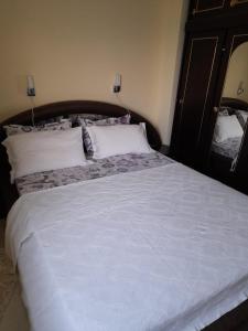 a bedroom with a large bed with white sheets and pillows at Nasty Apartament in Costinesti