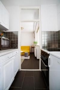 een keuken met witte kasten en een gele bank bij Old Town SCHarajevo - Free Parking in Sarajevo